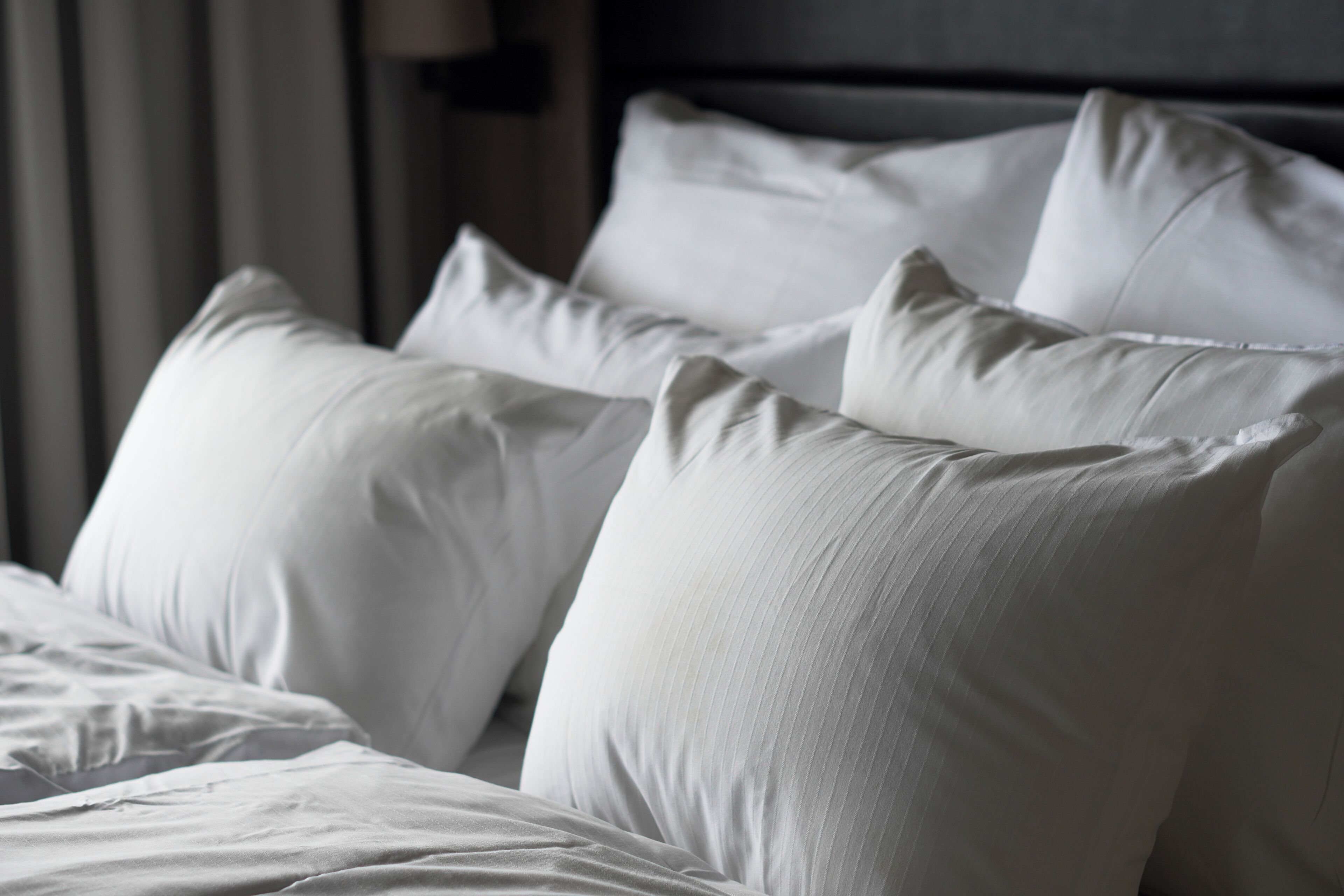 A bed with white bedding and pillows.