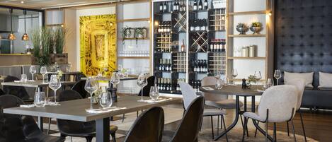 A modern dining area with tables, chairs, and wine racks.