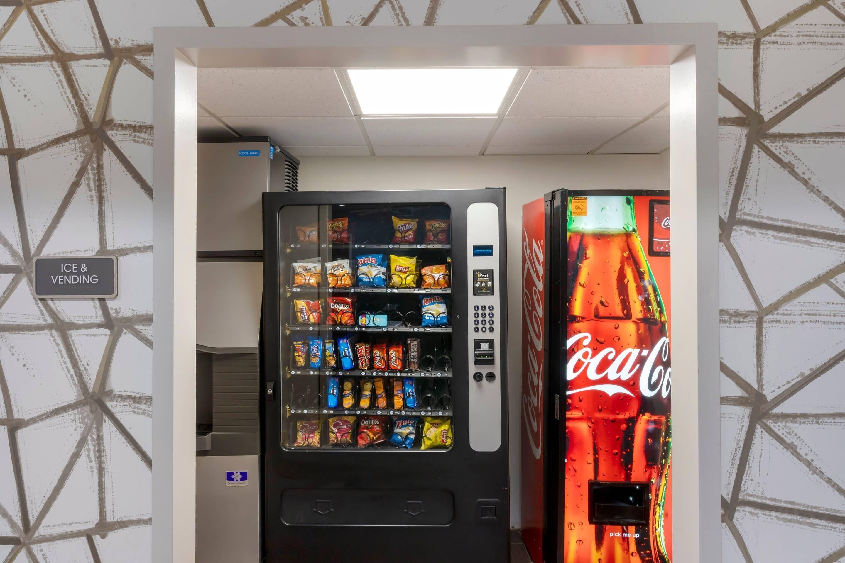 Máquina expendedora con aperitivos y una máquina de Coca-Cola.