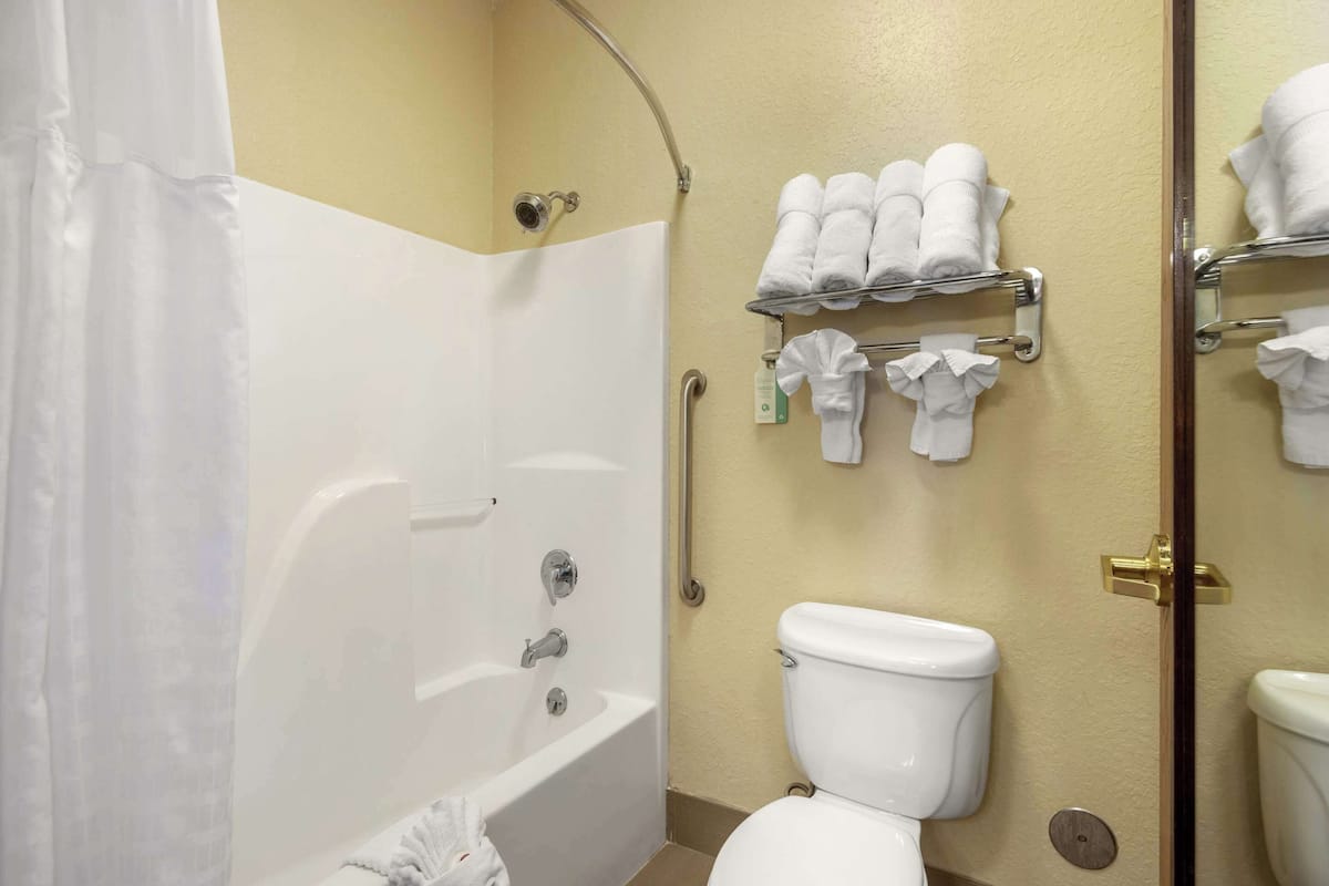 A bathroom with a bathtub, toilet, and towel rack.