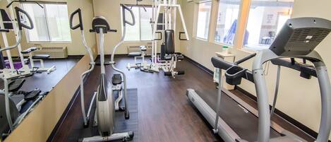 A gym with treadmills, elliptical machines, and weight machines.