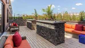 Un patio al aire libre con paredes de piedra, mesa de billar y zonas de estar.