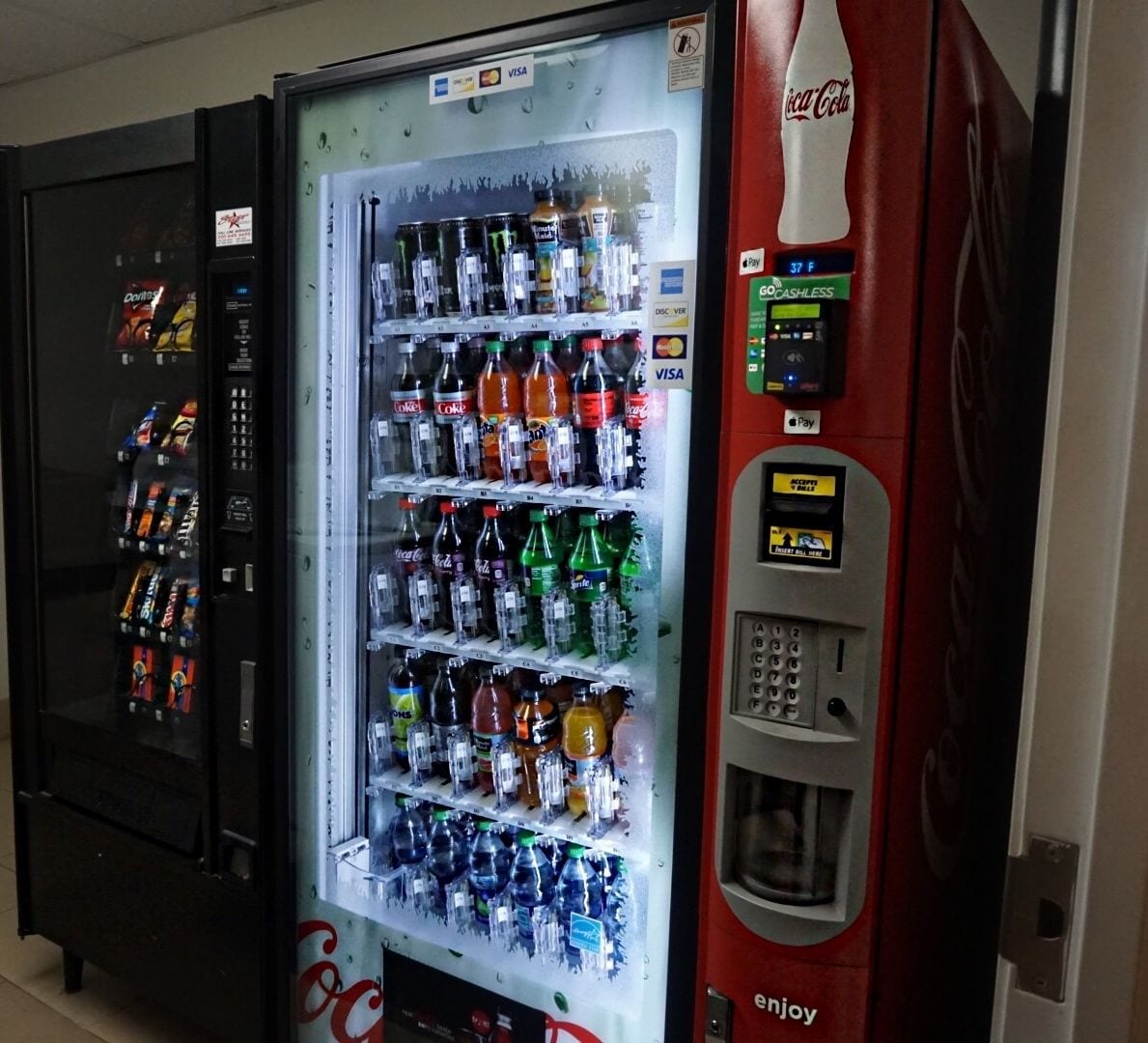 Myyntiautomaatti, josta on saatavilla erilaisia juomia ja pikkupurtavaa, kuten Coca-Colaa ja Doritos-sipsejä.