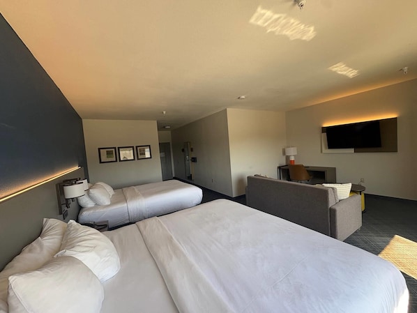 A hotel room with two beds, a desk, a TV, and a seating area. - Comfort Suites Crossville (Crossville)