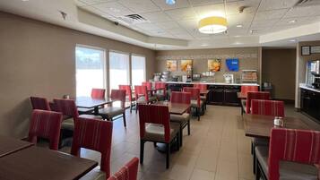 A restaurant with booths and tables, a counter with a menu, and a view of the outdoors.