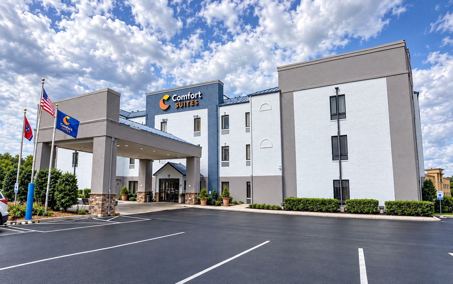 A Comfort Suites hotel with a covered entrance, multiple floors, and a parking lot.