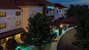 A Courtyard by Marriott hotel with a modern design, featuring multiple buildings connected by a covered walkway. - Courtyard by Marriott Tallahassee North/I-10 Capital Circle (Tallahassee)