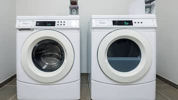 Dues rentadores frontals Whirlpool blanques una al costat de l'altra sobre un sòl de rajola.