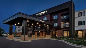 A Courtyard by Marriott hotel with a covered entrance, multiple floors, and a parking area. - Courtyard by Marriott Traverse City (Traverse City)