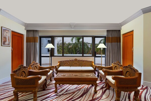 A room with a large window, a sofa set, and a patterned carpet. - Le Royal Meridien Chennai (Chennai)