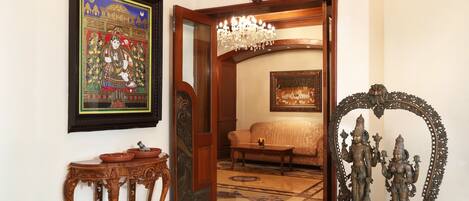 Una habitación de diseño tradicional, con una lámpara de araña, un sofá y un espejo decorativo.