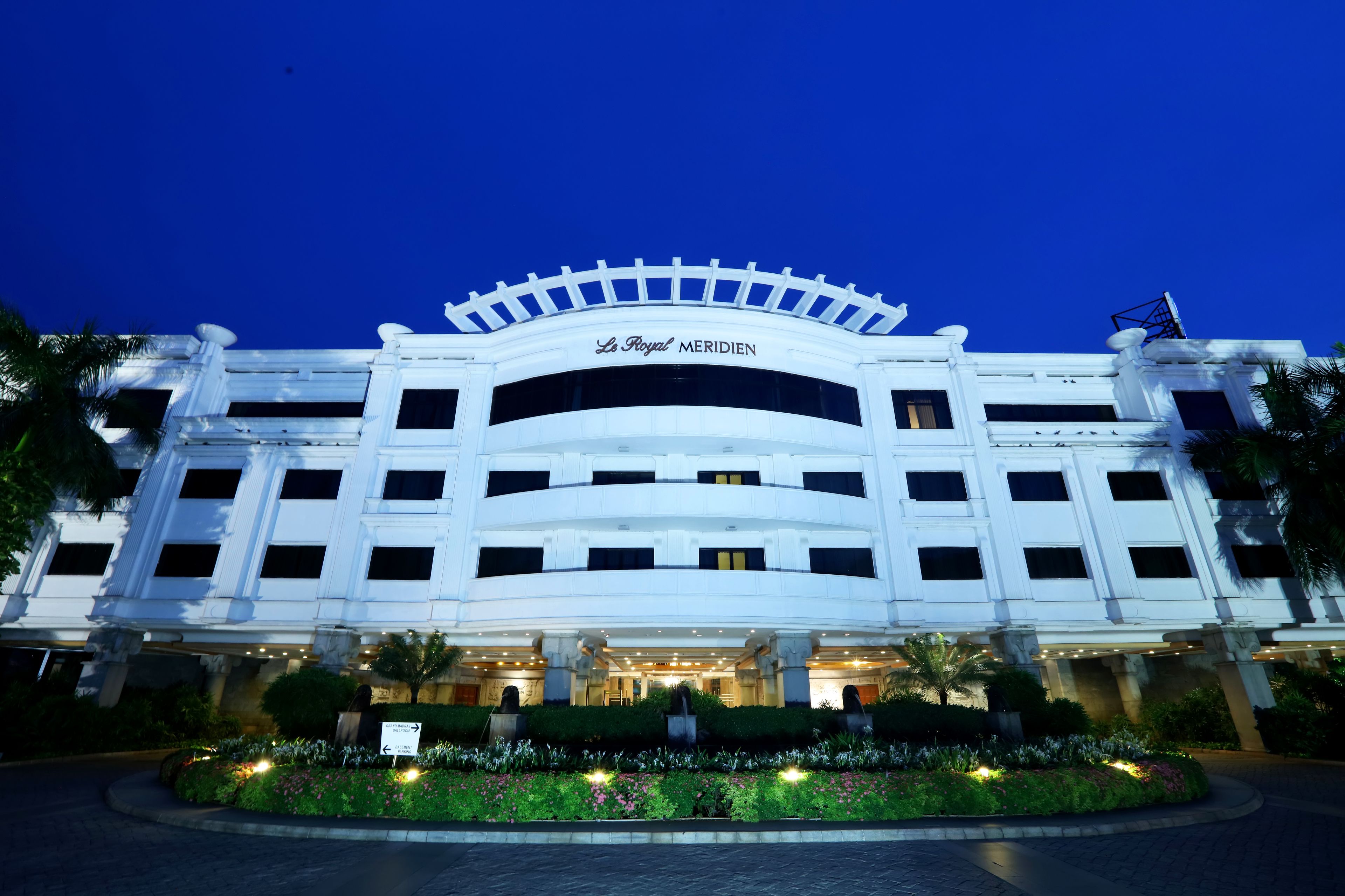 A large, white hotel with a classic architectural style, featuring multiple floors and a prominent entrance.