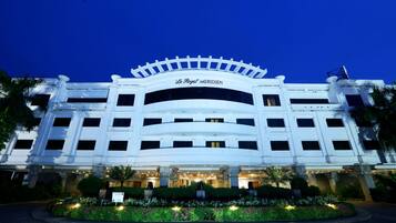 A large, white hotel with a classic architectural style, featuring multiple floors and a prominent entrance.