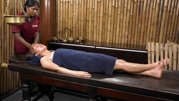 Experience a traditional spa treatment on a comfortable massage table, attended by a skilled masseuse.