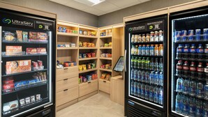 Un espace équipé de distributeurs automatiques de boissons fraîches et de présentoirs de snacks, où les clients peuvent se servir eux-mêmes.