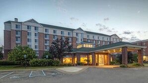 A multi-story hotel with a covered entrance and a parking lot.