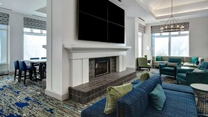 A spacious living area with a fireplace, comfortable seating, and large windows.