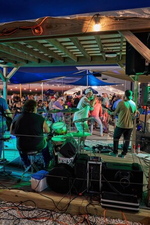 A stage with musical equipment and performers, surrounded by an audience. - Seaport Resort & Marina (Fairhaven)