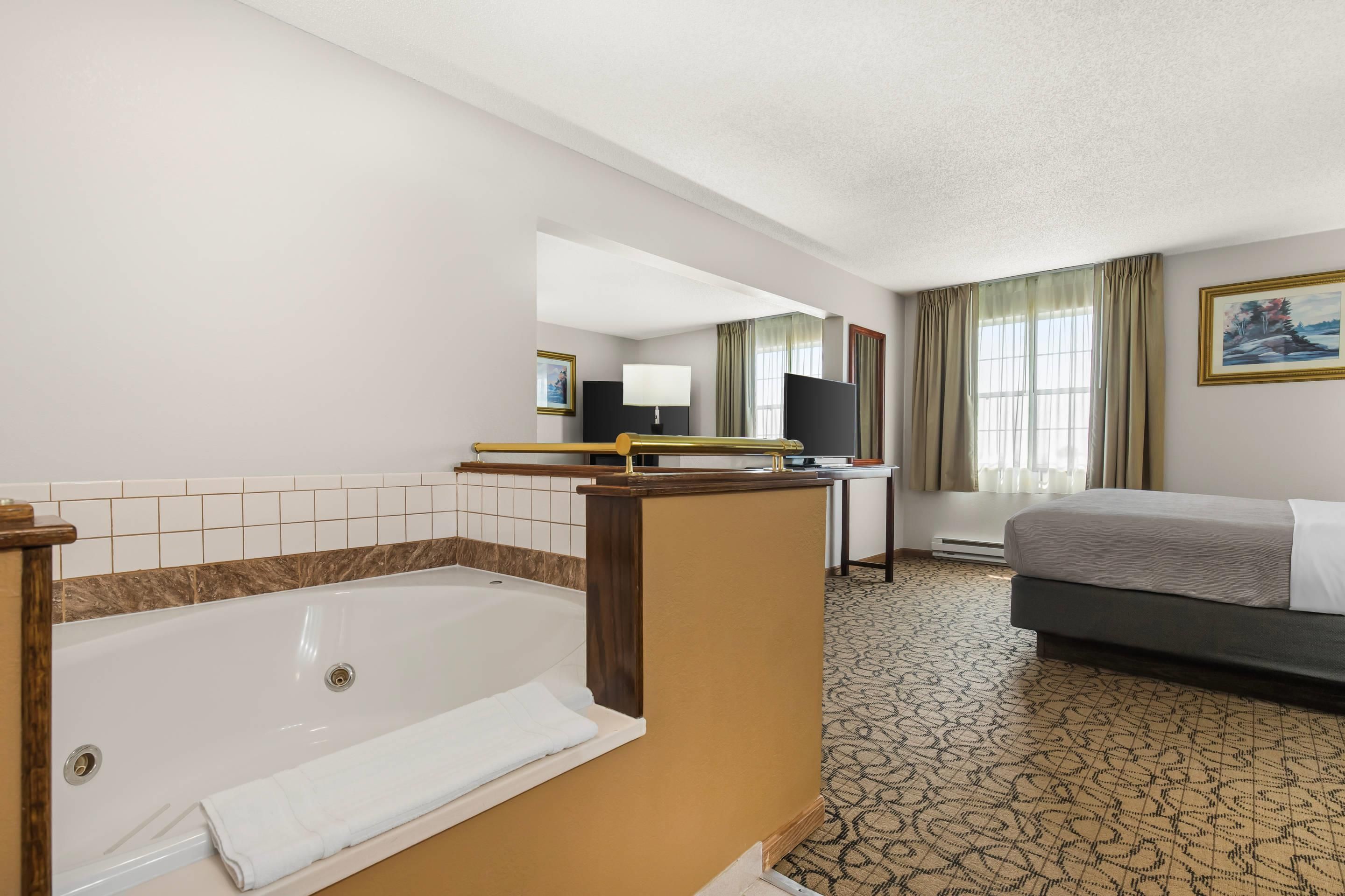 Hotellin kylpyhuone, jossa on kylpyamme, pesuallas ja peili.