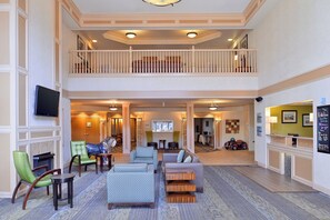 A spacious lobby with a high ceiling, a balcony, and a check-in counter. - Holiday Inn Express & Suites St Joseph by IHG (Saint Joseph)