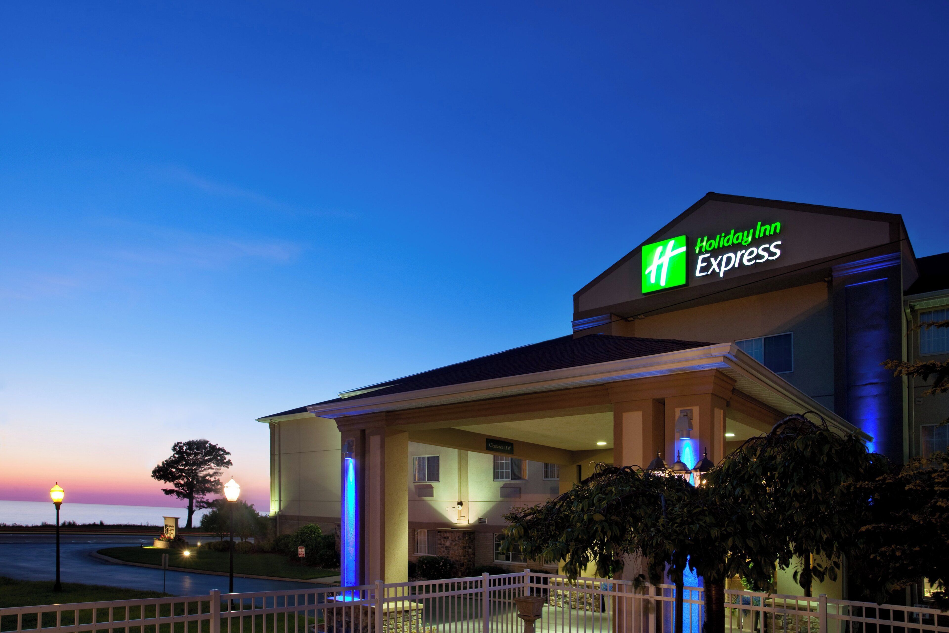 Un bâtiment de la chaîne Holiday Inn Express, reconnaissable à son enseigne bien visible, à son entrée abritée et à sa façade bien éclairée.