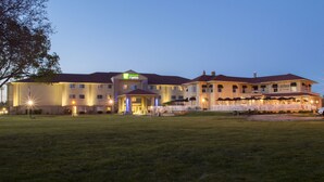 Un grand hôtel, facilement reconnaissable à son grand panneau « Holiday Inn Express », doté de nombreux balcons et d’une entrée bien éclairée.