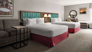 A hotel room with two beds, a sofa, a small table, and a nightstand. - Hampton Inn Sturbridge (Sturbridge)