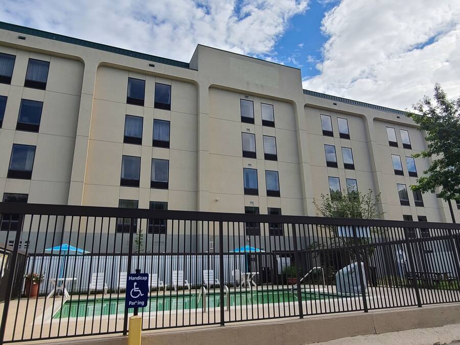 A modern building with a pool area, including a handicapped parking sign.