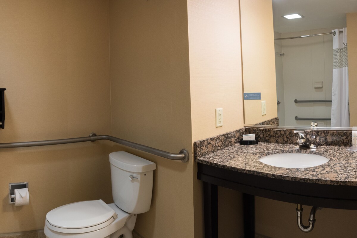 Un baño con inodoro, lavamanos y espejo.