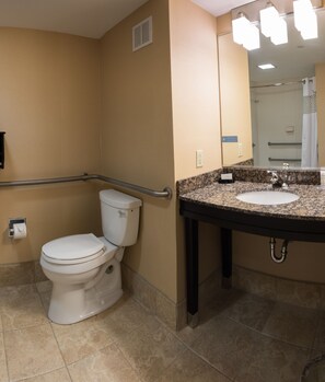 Un baño con inodoro, lavamanos y espejo.