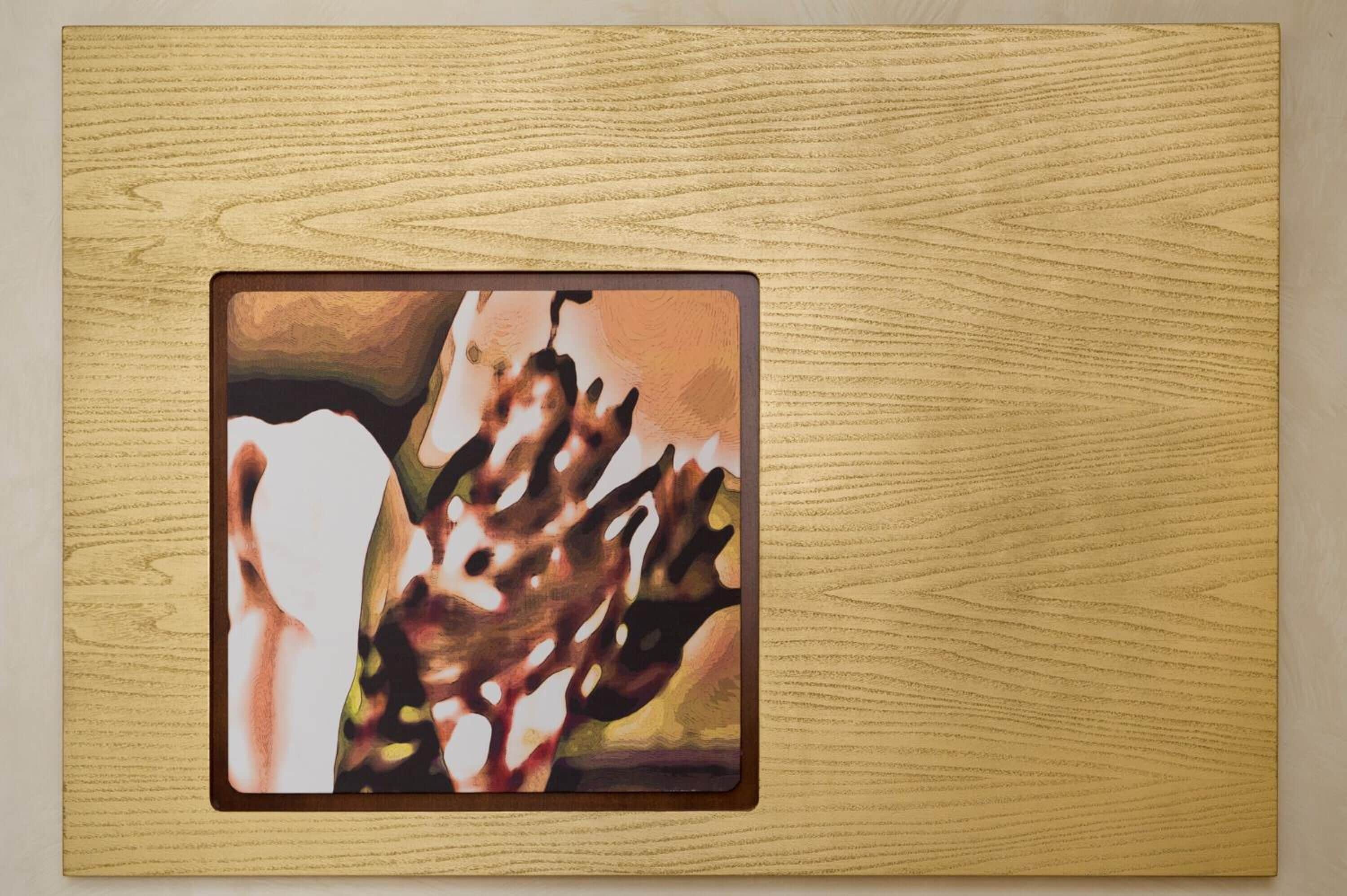 A framed artwork on a wooden surface.