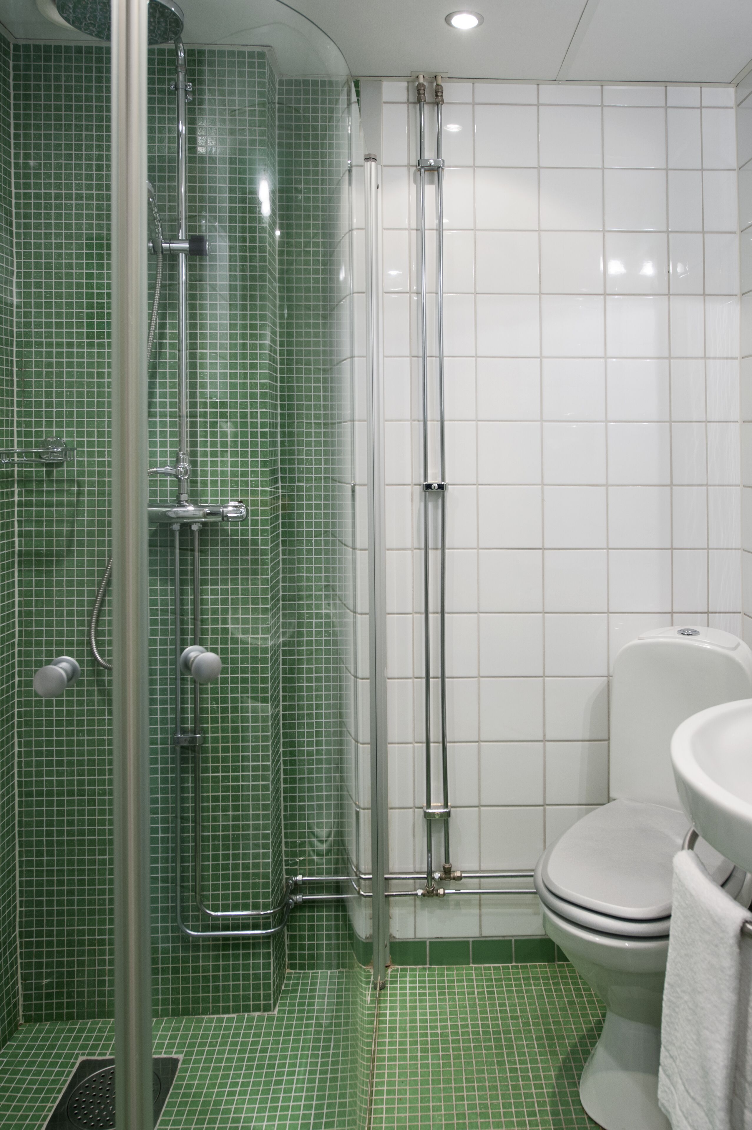 A bathroom with a shower, toilet, and sink.