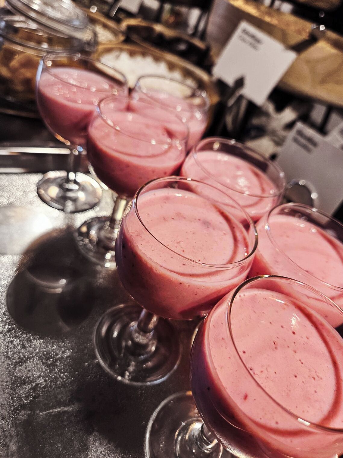 Μια ποικιλία ροζ smoothies σε διάφανα ποτήρια, τοποθετημένα σ ε ένα μεταλλικό δίσκο.