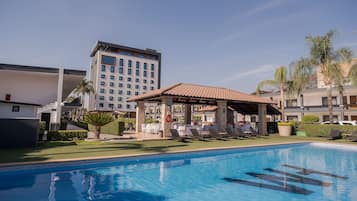 Relax by the pool surrounded by lounge chairs and a covered seating area.