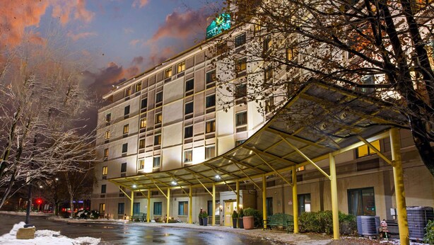 A multi-story hotel with a covered entrance and a snow-covered ground. - La Quinta Inn & Suites by Wyndham Boston Somerville (Somerville)