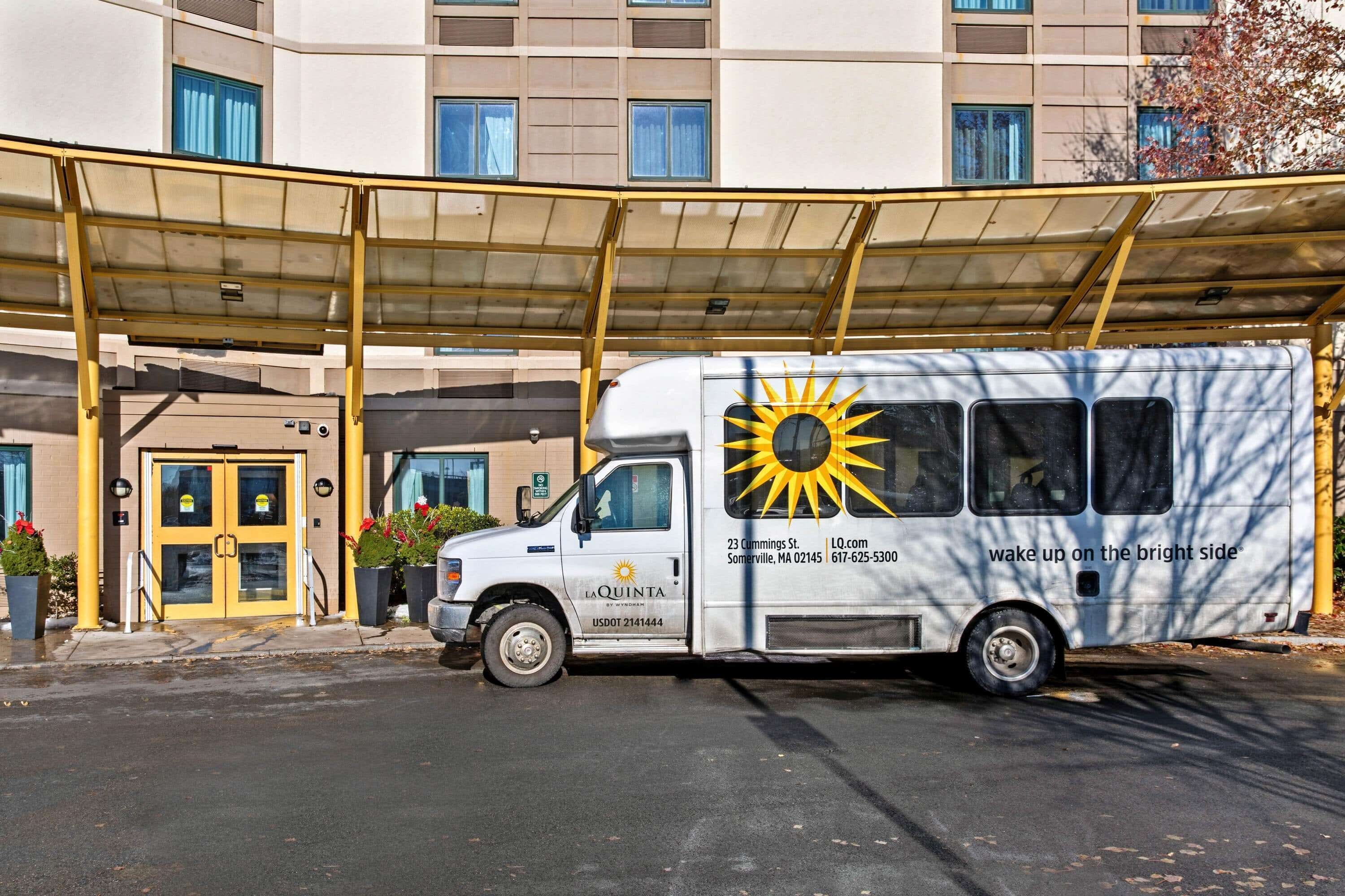 A white delivery truck parked in front of a building with a yellow awning.