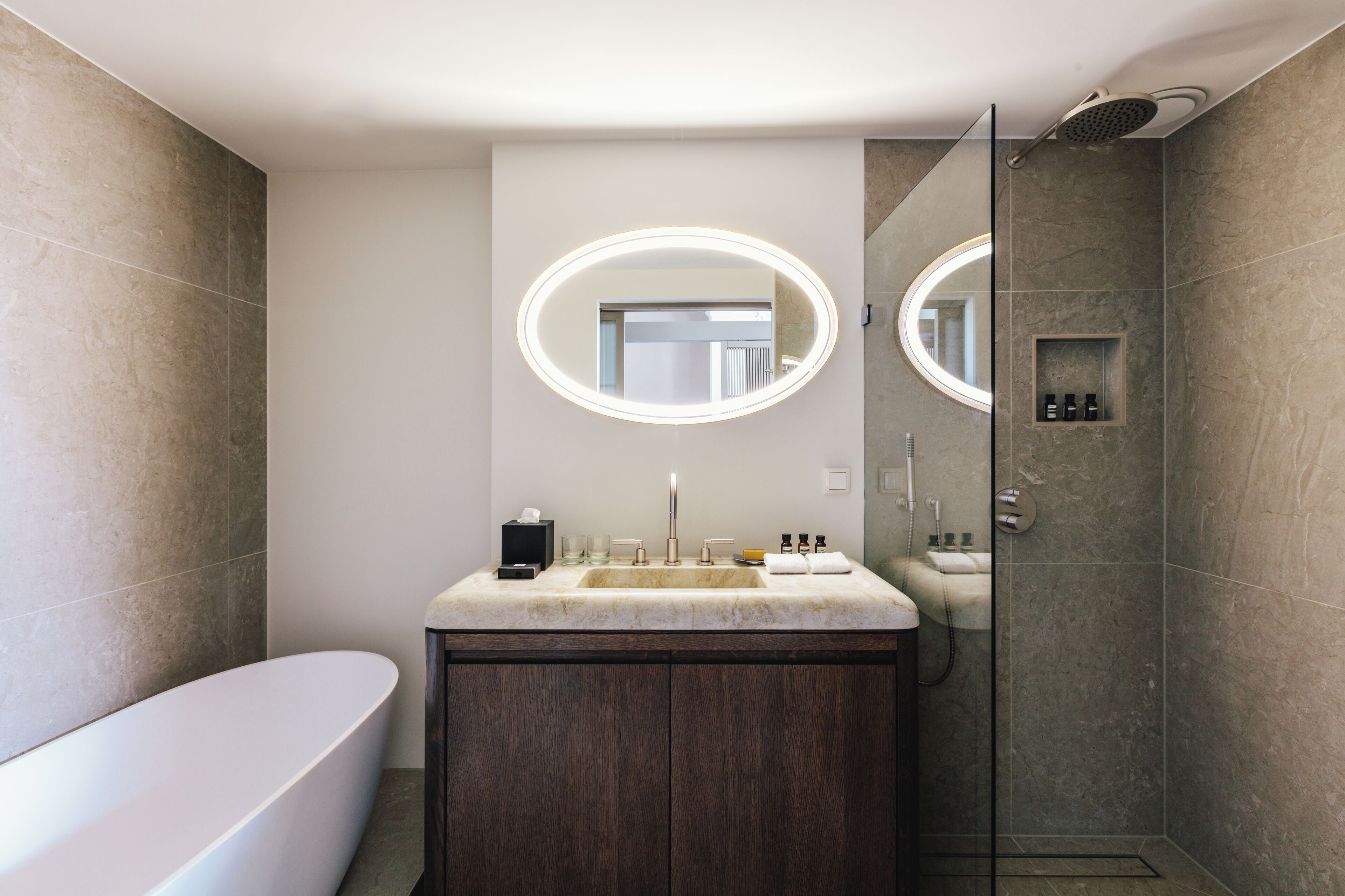 Un baño moderno con una bañera independiente, un tocador con lavabo y una zona de ducha.