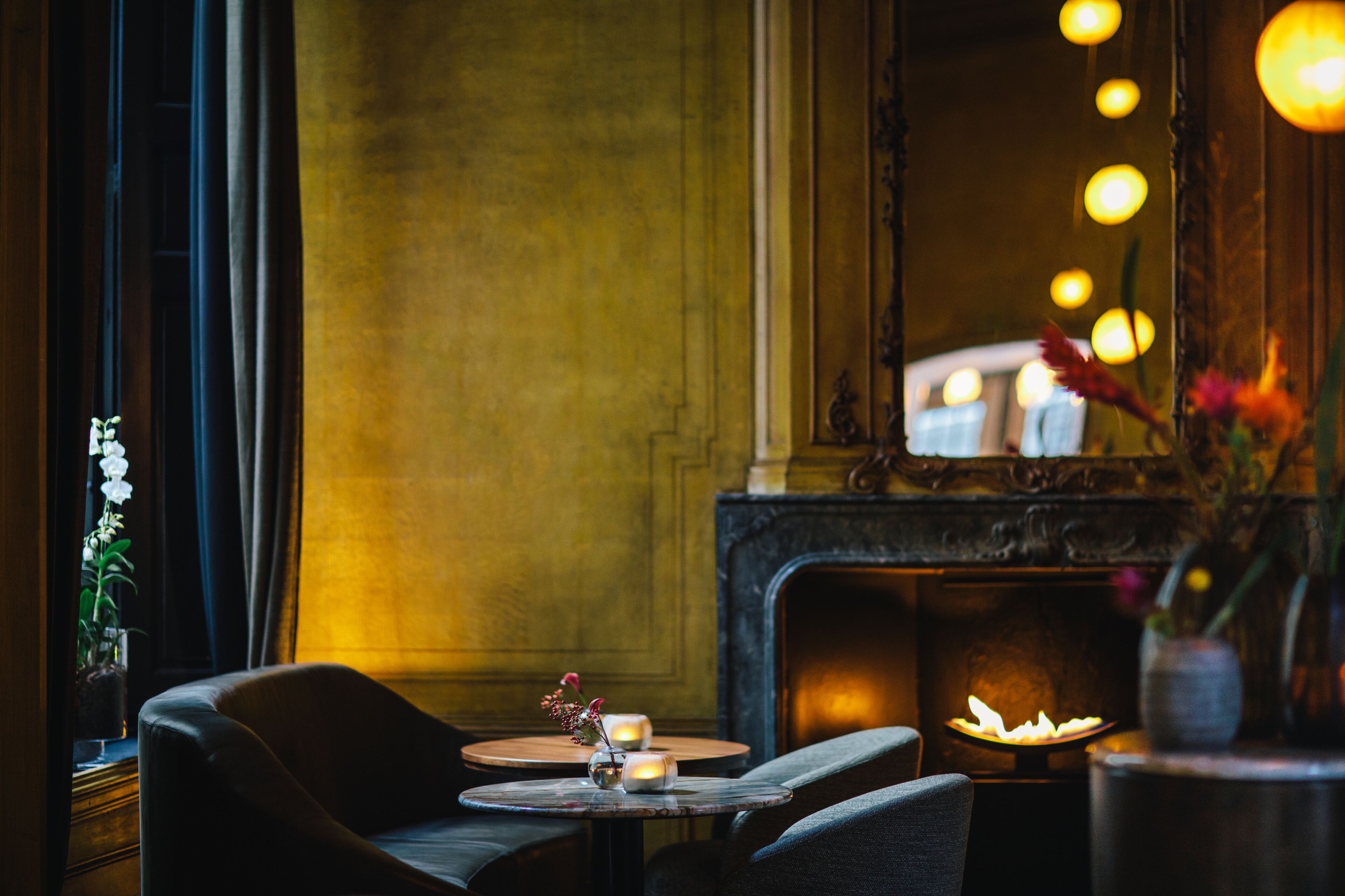 Una habitación acogedora con chimenea, una mesa redonda con velas y un rincón de descanso cómodo.