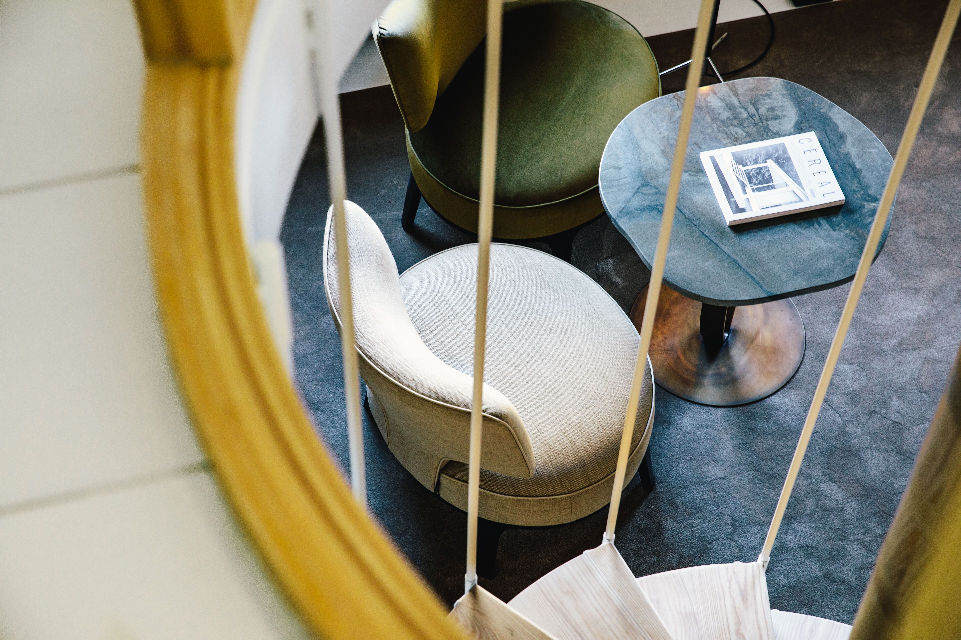 A modern interior with a round, cushioned seating area, a small table, and a book on the table.