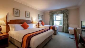 Een hotelkamer met twee bedden, een bureau en een televisie.