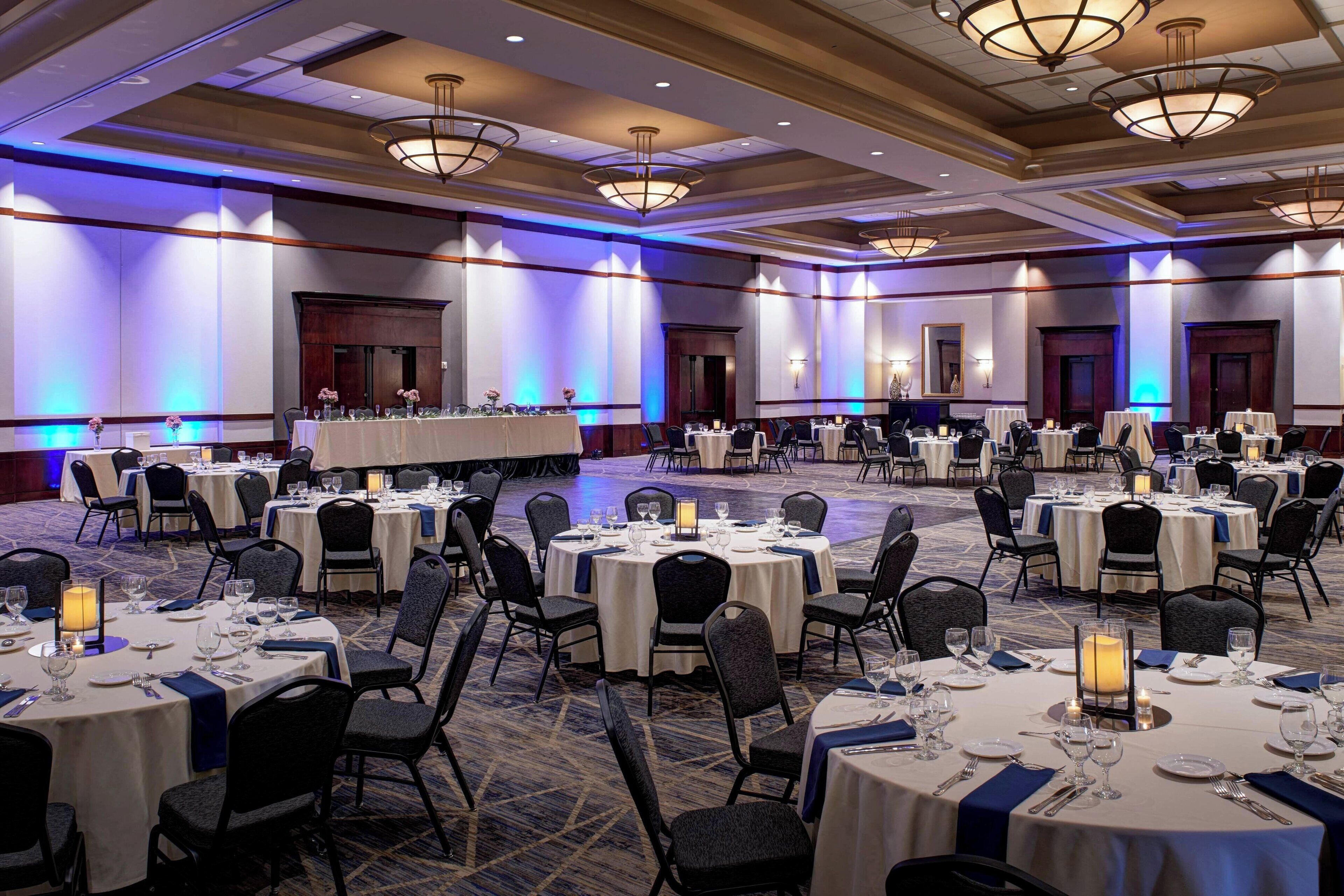 A banquet hall with round tables set for dining, equipped with chairs and table settings.
