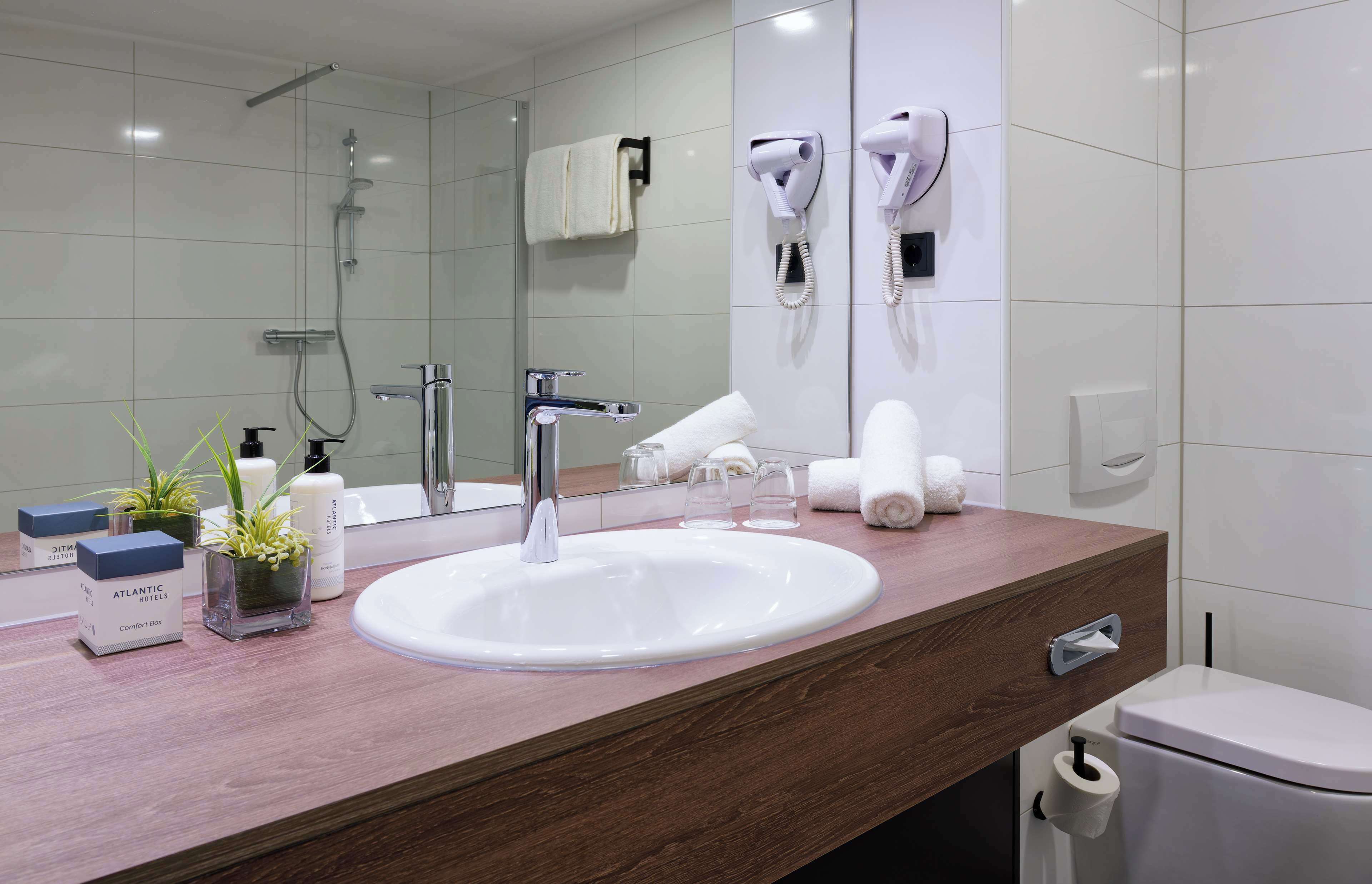 deluxe room | bathroom | hair dryer, slippers, towels, soap