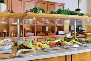 Un buffet proposant divers plats et un menu avec deux options, chacune ayant reçu une distinction « Gourmand ».
