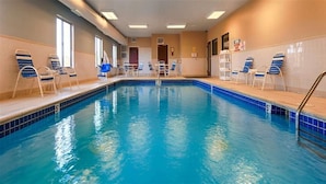 A swimming pool with blue tiles, lounge chairs, and a tiled wall. - Best Western Port Huron Blue Water Bridge (Port Huron)