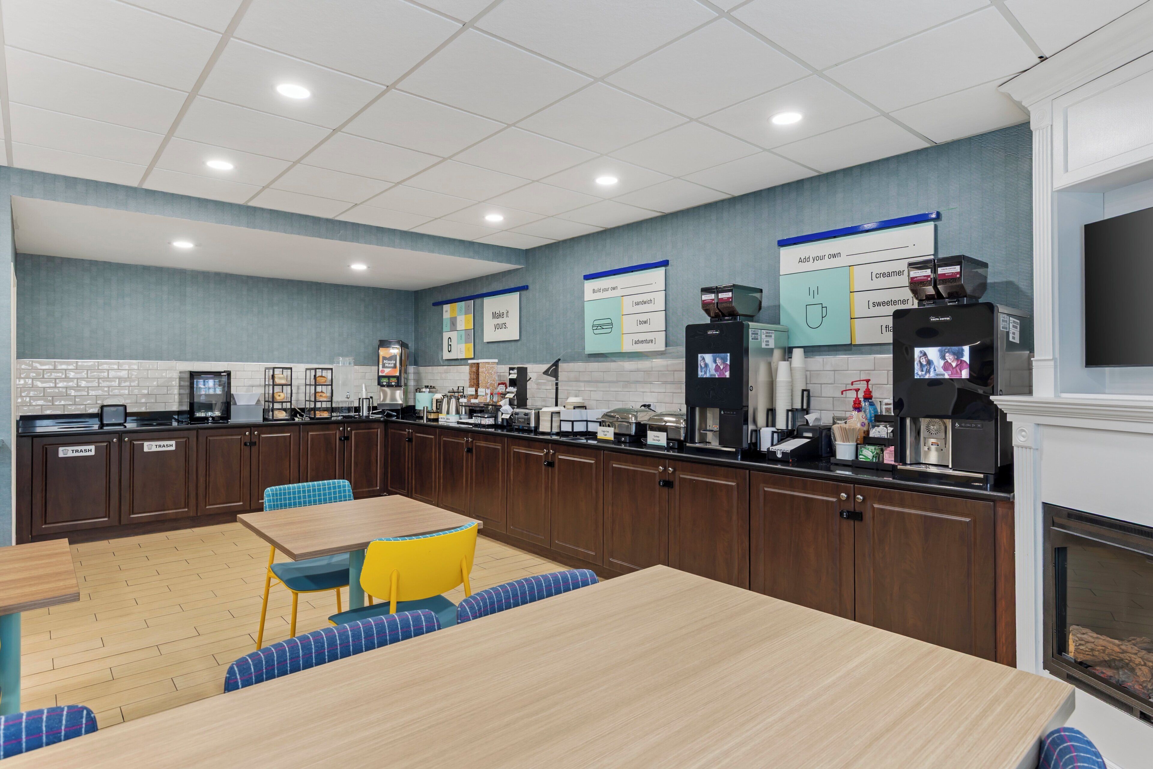Un'area cucina moderna con angolo caffè, salottino e camino.