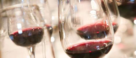 Multiple wine glasses filled with red wine, likely in a dining setting.
