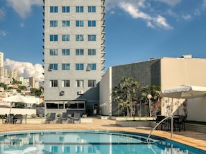 Una piscina al aire libre, tumbonas