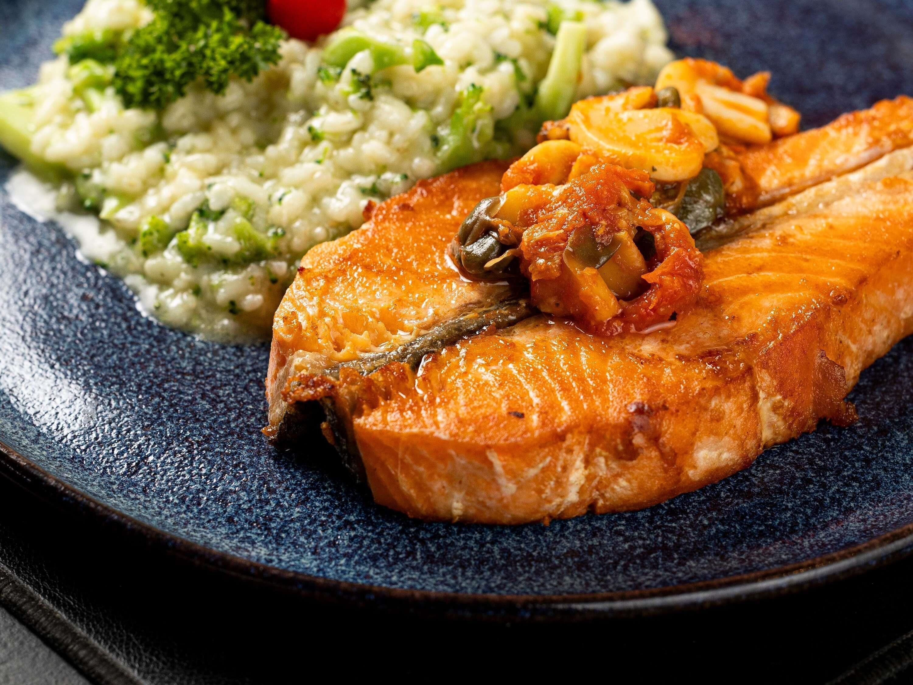 A plate with salmon, risotto, and vegetables.