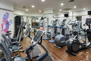 A gym with various exercise equipment including treadmills, elliptical machines, and weight machines.