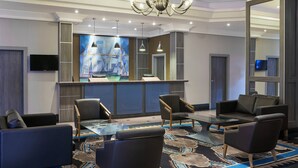 A modern lobby with a reception desk, seating area, and a chandelier. - Leonardo Hotel Middlesbrough (Middlesbrough)